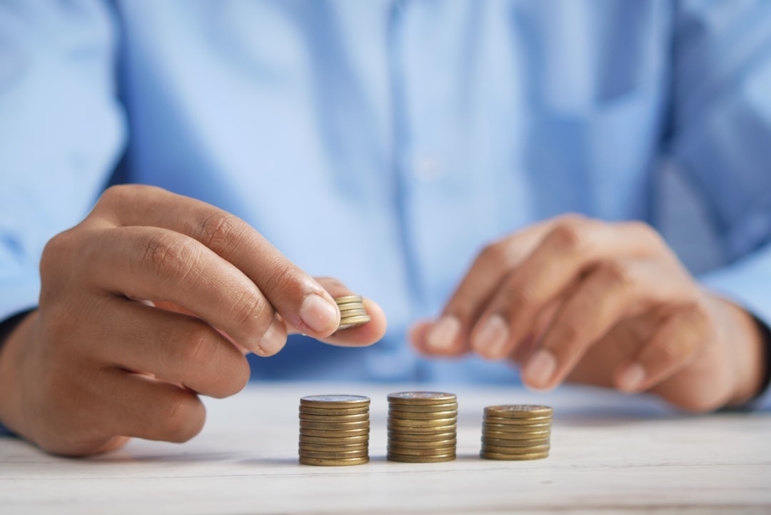 Mão segurando cartão perto de calculadora, representando a escolha entre poupar e investir